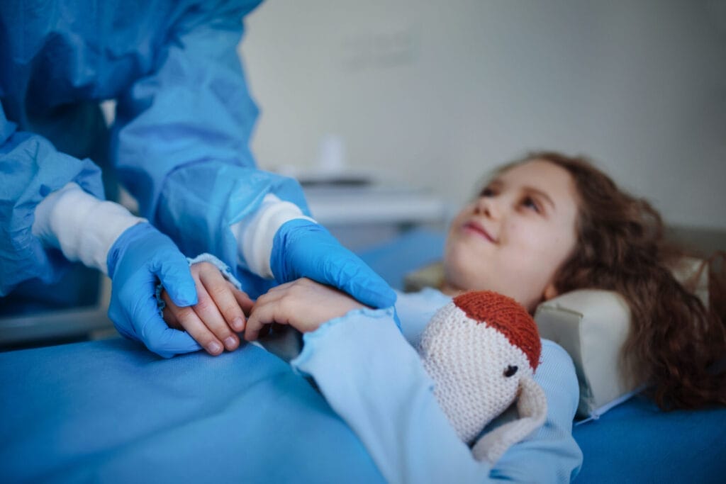 close up of doctor taking care of little girl in hospital ward after dermoid cyst surgery.